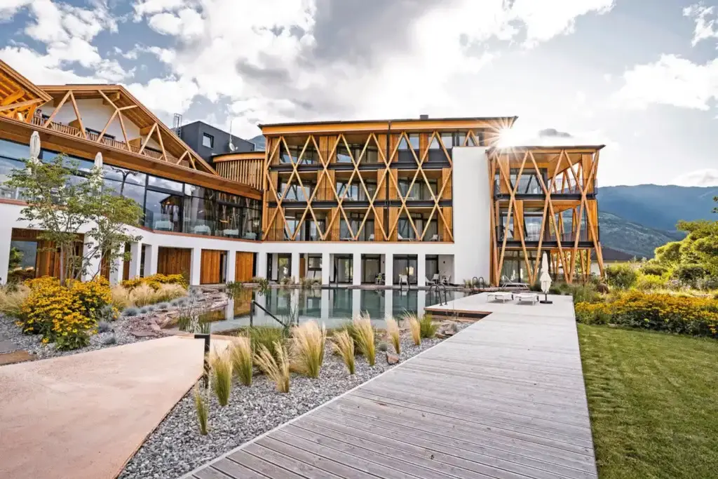 Wellnessoase inmitten sonniger Obsthänge mit Infinity-Pool und Panoramablick auf unberührte Berglandschaft – ideal für erholsamen Wellnessurlaub in Südtirol.